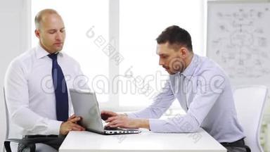 两个带着笔记本电脑微笑的商人